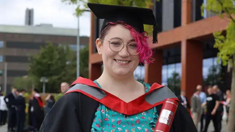 Staffordshire University Opal Raine smiling while wearing a graduation cap and gown