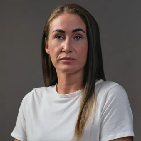 BBC Scotland Shannon, who has long, dark hair, is wearing a white T-shirt. 