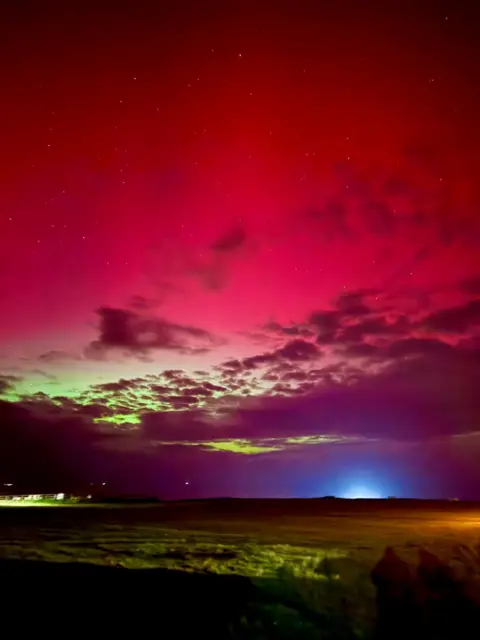 JODIE SEABROOK Red and greeny yellow northern lights over Alderney 