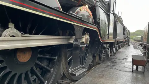 The side profile of a black locomotive.