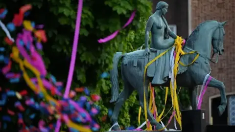 Getty Images The statue of Lady Godiva is covered in colourful paper streamers 