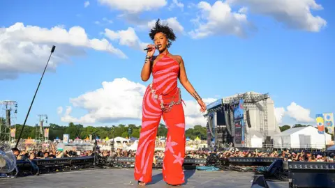 Nigerian Afropop star says 'women are not respected in the industry' Getty Images Tems performs on an outdoor stage in front of large crowd. She wears a bright, pink and red outfit.