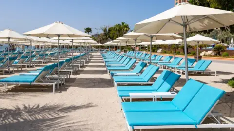 AFP via Getty Images Empty sunbeds at a hotel in Dubai
