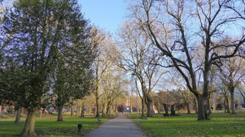 Whitworth Park in Rusholme - path leads up to art gallery with grass and trees on both sides