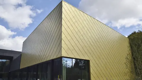 Anglia Ruskin University Part of ARU Peterborough's new lab - a futuristic square-shaped building with gold tiles.