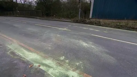 The surface of Dartmouth Road covered in scrapes which have been covered by sand