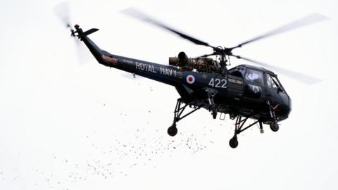 Poppy petals are dropped from a Wasp helicopter off the coast of Portland in Dorset,