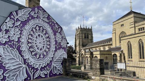 Lace artwork celebrating Bradford's textile heritage, next to Bradford Cathedral