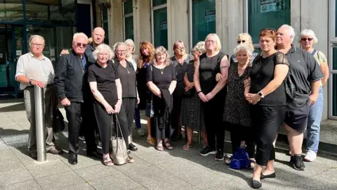 Campaigners against the closure of Northbrook swimming pool wearing black outside the Exeter City Council headquarters 