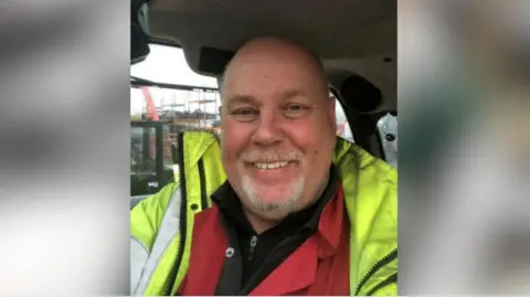 HSE Chris Keegan wearing a hi-vis jacket and smiling.
