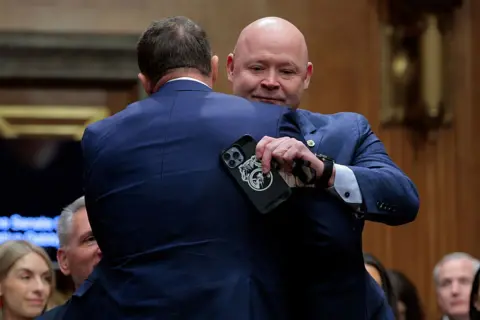 Getty Images Mullin and O'Brien hug while wearing blue suits