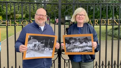 Whittle Productions David Clargo and Carole Sleight of Whittle Productions holding photos from the 1950s festival while standing by the gates of Jephson Gardens
