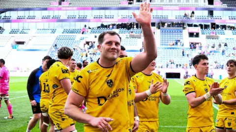 Dragons co-captain Ben Carter waves to the crowd after helping his side beat Stade Francais