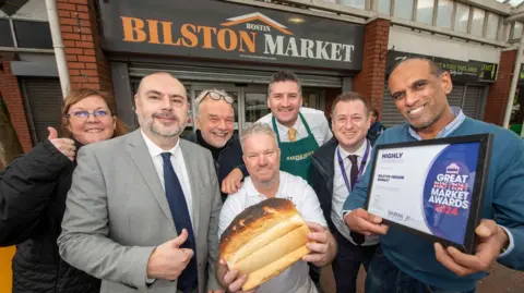 City of Wolverhampton Council People celebrate with the award and a loaf of bred in the indoor market