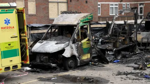 PA Media The burnt out remains of Hatzola ambulances at the Jewish Community Ambulance service in in Golders Green, London