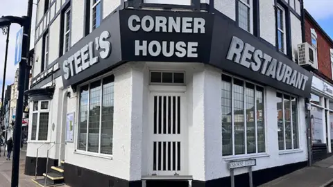 Natalie Bell / BBC The black and white exterior of Steels restaurant, which occupies a corner plot in Cleethorpes