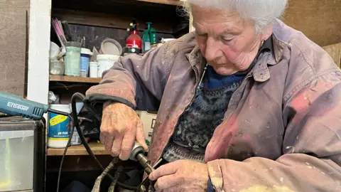 Jan is an elderly lady, and she sits in her overalls in her studio grinding and polishing a sculpture of a galloping horse
