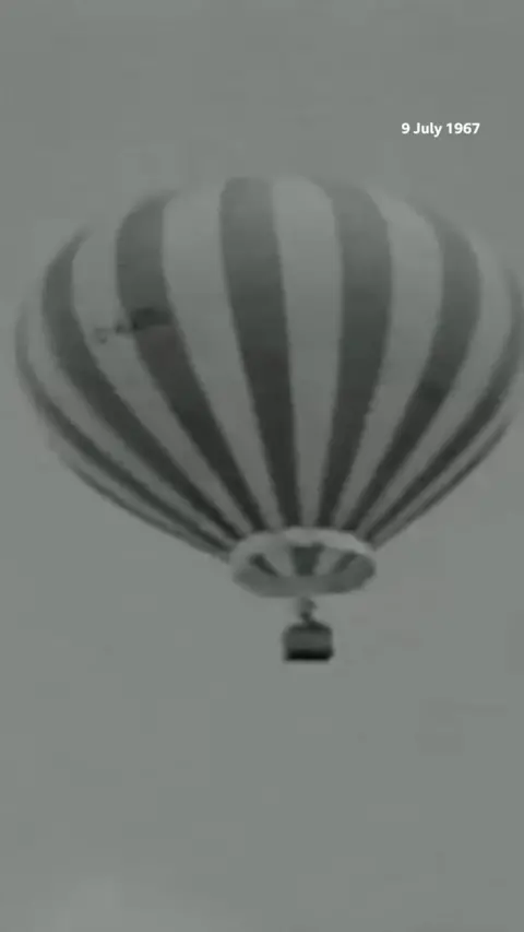 Black and white image of hot air balloon in the air
