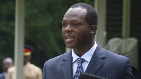 Raphael Tuju in a dark blue suit and light blue shirt