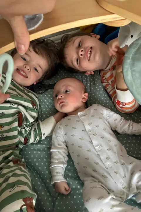 Family Photo Big brothers huddle around a baby