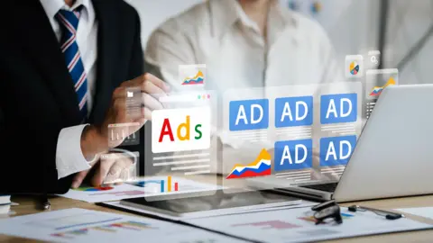 A graphic illustration of online adverts floating above a laptop screen