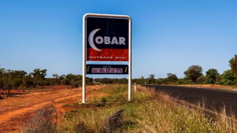 Getty Images A sign reading 'Cobar' beside a road in the Australian outback