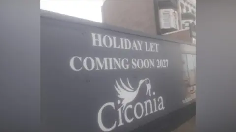 Local Democracy Reporting Service A hoarding sign board at the development with the words 'HOLIDAY LET COMING SOON 2027 CICONIA'