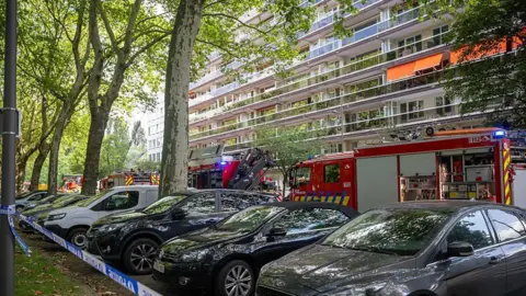 BELGA MAG/Belga/AFP A streetview of firefighters at the scene of a fire in an apartment building in the August Vermeylenlaan street in Antwerp