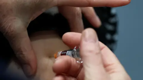 A member of the Kent Community Health NHS Trust immunisation team administers Meningitis B vaccination, GSK (GlaxoSmithKline) Bexsero meningococcal group B vaccine, mainly to students, at a sports centre on the University of Kent campus, following an outbreak of meningitis cases in Kent.