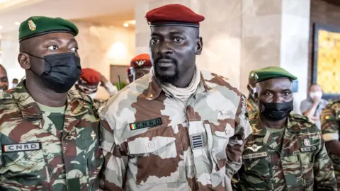 President of the National Committee for Rally and Development (CNRD) Colonel Mamady Doumbouya (C) leaves a meeting with high level representatives of the Economic Community of West African States (ECOWAS) in Conakry on September 17, 2021