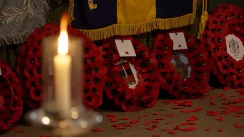 A close up of wreaths of poppies leaning up against the alter at Lincoln Cathedral.