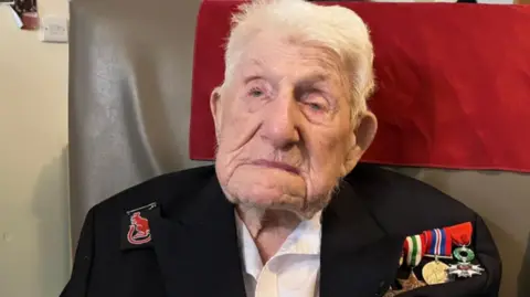 An image of an elderley man with his war medals