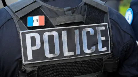 The bulletproof vest of an unidentified police officer is seen from behind in an archive image. The vest says 'Police' and has a badge bearing the French flag on.