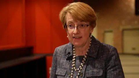 Susan Hinchliffe looking across camera while speaking to the BBC