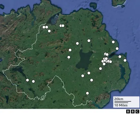 A map of Northern Ireland showing the location of 30 murders of women. The map is green with the locations highlighted by a white dot.