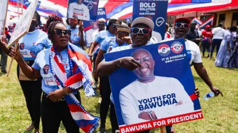 AFP Supporters hold a placard depicting the portrait of Mahamudu Bawumia in Takoradi on 18 August 2024