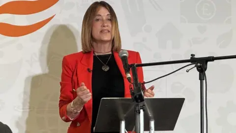 Jane Dodds standing at podium addressing an audience