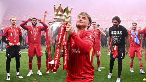 Liverpool midfielder Harvey Elliott lifts the Premier League trophy