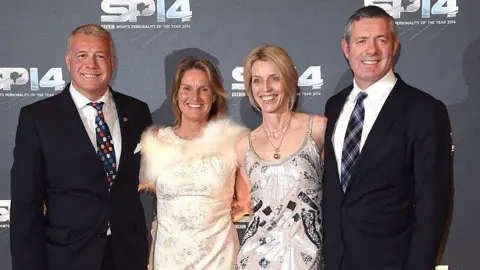 Getty Images Scott Hastings (far left) and his brother Gavin (far right) with their wives Jenny and Diane 