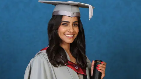 Mandip Gill in cap and gown holding her certificate