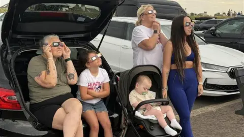 People gathered at Ayr Beach to see the eclipse 