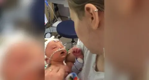 Family handout Baby Orlando in his mothers arms and looking up at her