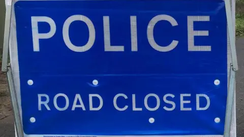 Sign reading: 'POLICE. ROAD CLOSED'