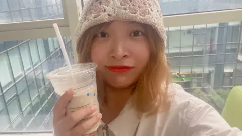 Tina poses for photo while holding bubble tea beverage.