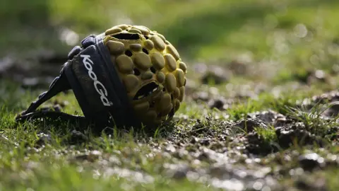 A rugby scrum cap on the ground
