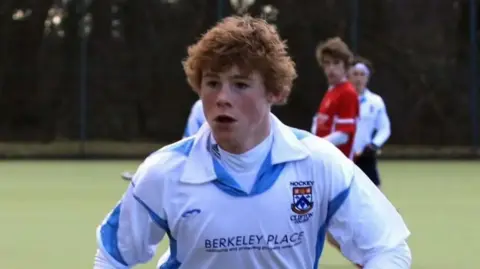 Charlotte Bresnahan Ryan Bresnahan wearing a white hockey top, playing hockey