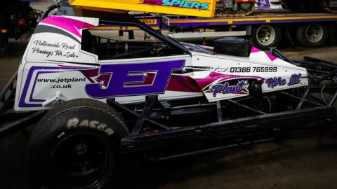 CWA A white and purple race car reading "Jet" on the side, with smaller text including a phone number