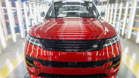 Front of a bright red Land Rover in a JLR factory