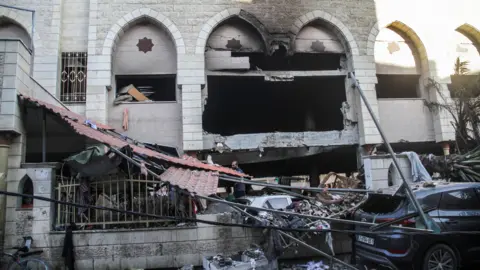 Mahmoud Zaki/EPA-EFE/REX/Shutterstock Palestinians survey the damage following an Israeli attack on al-Tabai school in Gaza.