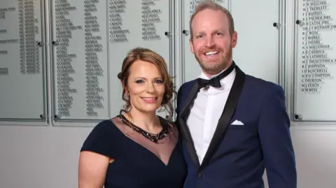 Donna Stevens Mr and Mrs Stevens wearing smart evening wear at an event smiling at the camera